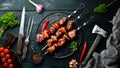 Shish kebab BBQ meat with onions and tomatoes. On a black background. Top view. Royalty Free Stock Photo