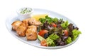 Shish kebab from salmon with vegetables and salad. On a white plate Royalty Free Stock Photo