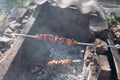 Shish pork meat on the open fire. Handmade barbecue place from stones and bricks. Summer tasty food