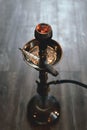 Shisha hookah bowl with red hot coals and craft tobacco. Sparks from breathe. Modern hookah with coconut charcoal for