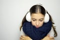 Shivering young woman looking down ill with flu or cold. Young woman being cold wearing earmuffs, scraf and sweater. Copy space. Royalty Free Stock Photo