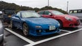 A blue Mazda RX-7 FD3S and a red Alfa Romeo Giulietta parked on the parking lot