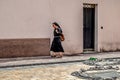 Albanian nun walks down the street along a light wall in Shkored
