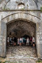 A group of tourists inside the arched corridor in Rozafa Castle