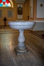 A stone baptismal bowl with the Italian inscription  Dono della famiglia Pemma, 1878  in the Catholic Grand Church in Shkodra Royalty Free Stock Photo
