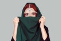 Shock. Beautiful woman shocked eyes wide open covers her face with a green cloth scarf. Fashion islamic style girl Royalty Free Stock Photo