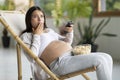 Shock Content. Scared Pregnant Woman Watching Tv And Eating Popcorn At Home Royalty Free Stock Photo