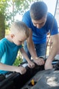 Timing belt break. Man and son near hood of car is looking for a malfunction due to which the engine does not work. Driver is Royalty Free Stock Photo