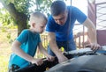 Timing belt break. Man and son near hood of car is looking for a malfunction due to which the engine does not work. Driver is Royalty Free Stock Photo