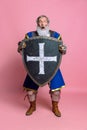 Shock. Portrait of senior grey bearded man, brave medieval warrior or knight in armored clothes with sword isolated on