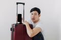Shock and surprise face of man using mobile phone application for travel, sitting with his baggage or luggage. Royalty Free Stock Photo