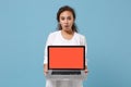 Shocked african american doctor woman isolated on blue background. Doctor in medical gown holding laptop pc computer Royalty Free Stock Photo