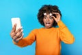 Shocked african american woman looking at phone and removing glasses Royalty Free Stock Photo