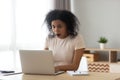 Shocked African American woman with open mouth using laptop Royalty Free Stock Photo