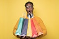 Shocked african young man holding shopping bags being surprises