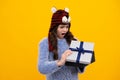 Shocked amazed face, surprised emotions of young teenager girl. Funny kid girl in winter wear holding gift boxes Royalty Free Stock Photo