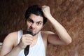 Shocked angry arab young man cutting hair with hair clipper Royalty Free Stock Photo