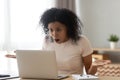 Shocked angry stressed african woman customer looking at laptop screen
