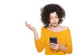 Shocked angry young girl looking at her mobile phone in disbelief. Teenager staring at shocking text message on her phone. Royalty Free Stock Photo