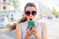 Shocked anxious scared young girl looking at phone seeing bad news Royalty Free Stock Photo