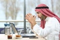 Shocked arab man checking laptop in a bar