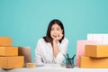 Shocked Asian businesswoman in white shirt sitting at her desk isolated on green background. with brown cardboard box Royalty Free Stock Photo