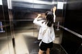 Shocked asian child girl is stuck in an elevator,sad teenager girl standing alone and screaming in a despair suffering from