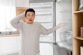 Shocked asian man pointing at empty fridge Royalty Free Stock Photo