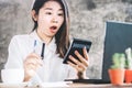 Shocked Asian woman hand counting expenses on calculator having problem with credit card Royalty Free Stock Photo