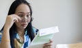 Shocked Asian woman reading some bills energy expenses on table in living room Royalty Free Stock Photo