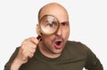 Shocked bald guy looking through magnifying glass Royalty Free Stock Photo