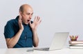 Shocked bald man looking at the laptop Royalty Free Stock Photo