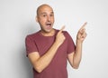 Shocked bald man pointing fingers aside. Isolated Royalty Free Stock Photo