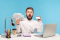 Shocked bearded man office worker holding dollar cash and credit card looking at camera with astonishment, surprised with high Royalty Free Stock Photo