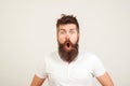 Shocked bearded man stares at camera. Bearded hipster guy widely opened mouth and eyes. Human face expressions and emotions. Wow!