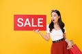 Shocked beautiful Asian woman showing red sale sign