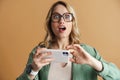 Shocked beautiful woman exclaiming and using mobile phone