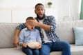 Shocked Black Father Covering Son& x27;s Eyes Watching Television At Home Royalty Free Stock Photo