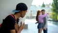 Shocked black teen guy looking girlfriend hugging classmate, unrequited love