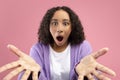 Shocked black woman looking at camera with open mouth, expressing amazement on pink studio background Royalty Free Stock Photo