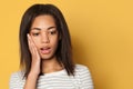 Shocked black woman with opened mouth on bright yellow background