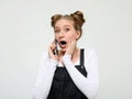 Shocked blond woman talking phone, listening to information with surprised expression, unbelievable. Royalty Free Stock Photo