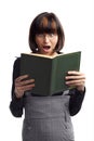Shocked brunette schoolgirl looking in the book Royalty Free Stock Photo