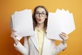 shocked business woman in suit holding documents on orange background, surprised girl manager with papers Royalty Free Stock Photo