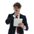 Shocked businessman holding tablet and hand over mouth, gasping
