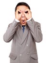 Shocked businessman looking through his circled fingers