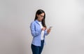 Shocked businesswoman in eyeglasses reading unexpected message over smart phone on white background Royalty Free Stock Photo