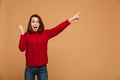 Shocked caucasian woman dressed in sweater pointing