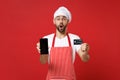 Shocked chef cook or baker man in striped apron t-shirt toque chefs hat isolated on red background. Cooking food concept Royalty Free Stock Photo