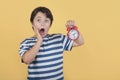 Shocked child holding alarm clock Royalty Free Stock Photo